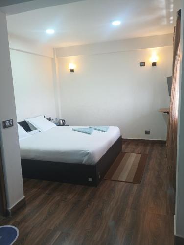 a hotel room with a bed and a wooden floor at Joyous Rooms in Cherrapunji