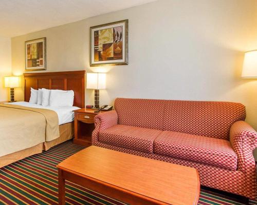 a hotel room with a bed and two couches at Quality Inn Dyersburg I-155 in Dyersburg