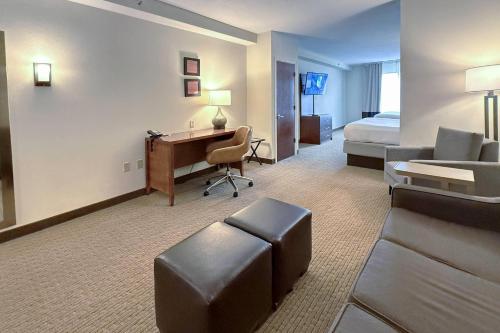 a hotel room with a bed and a desk and a bedroom at Comfort Inn & Suites Rogersville in Rogersville