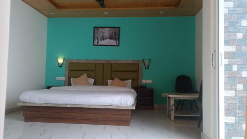a bedroom with a bed with a blue wall at Elite peak hotel in Kasauli