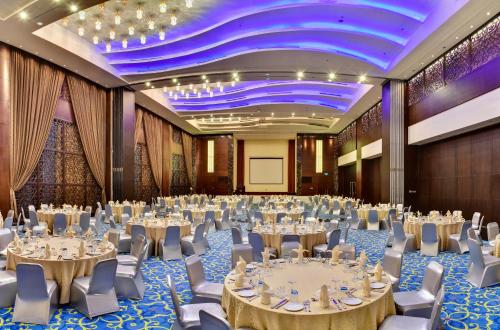a large ballroom with tables and chairs and a stage at Sofitel Al Khobar The Corniche in Al Khobar