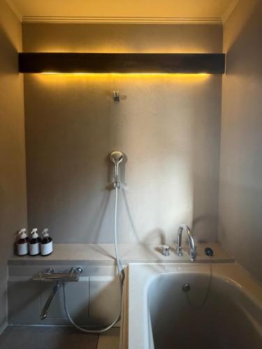 a bathroom with a bath tub and a sink at FUMI hakone 森の露天風呂 in Hakone