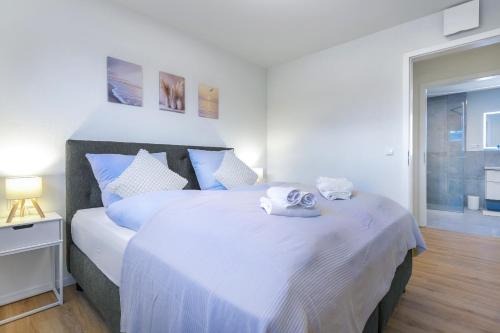 a bedroom with a large bed with towels on it at Lütt Mööv - Seestraße 8 4 in Kellenhusen