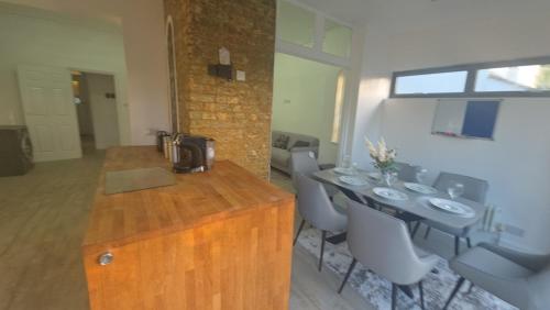 a kitchen with a wooden counter and a table and chairs at Superb luxury stay Croydon London in Thornton Heath