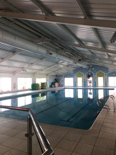a large swimming pool in a building at Dunes Views in Prestatyn