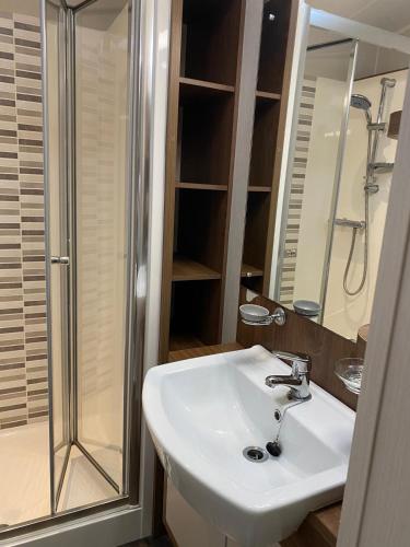 a bathroom with a white sink and a shower at The Suite in Tosside