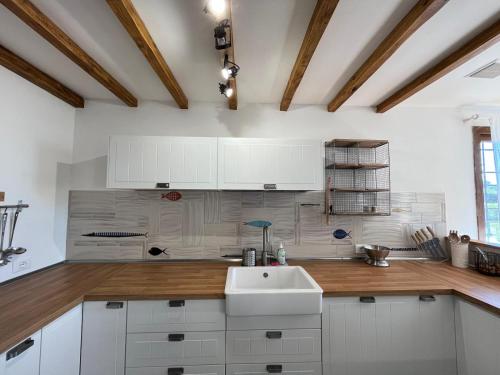 a kitchen with white cabinets and a sink at Osteria del Cavaliere B&B e Maneggio in Sacrofano