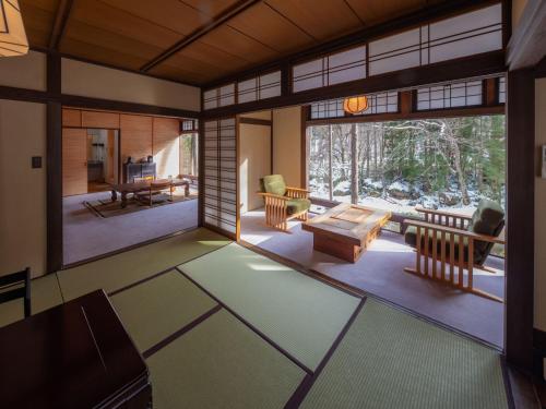 a living room with a large window and a table at Wanosato in Takayama