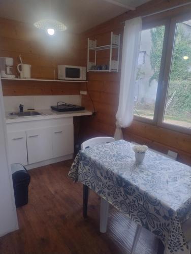 a small kitchen with a table and a window at Le petit chalet in Chanas