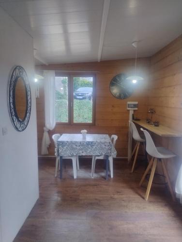 a dining room with a table and some chairs at Le petit chalet in Chanas