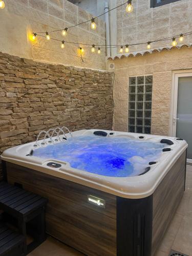 a jacuzzi tub in a room with a stone wall at Fuera de tiempo in Albalat de la Ribera