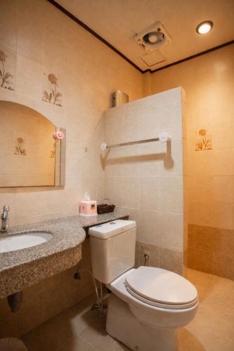 a bathroom with a toilet and a sink at Ban Ao Thong in Trang