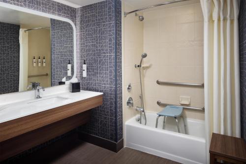 a bathroom with a sink and a tub and a toilet at Homewood Suites by Hilton Denver International Airport in Denver