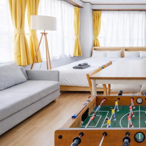 a living room with two beds and a foosball table at Large Private House for 18 Tokyo Tower JR Hamamatsucho 8min HOTEL Musashi Tokyo Shiba in Tokyo