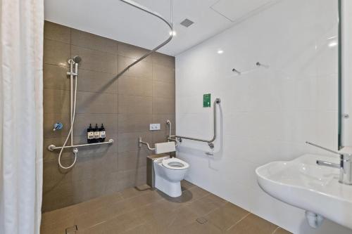 a bathroom with a shower and a toilet and a sink at The Kingsford, an Ascend Collection Hotel in Brisbane