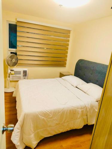 a bedroom with a white bed and a window at Seawind in Davao City