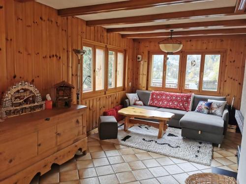 a living room with a couch and a table at Le balcon de Mâche in Hérémence