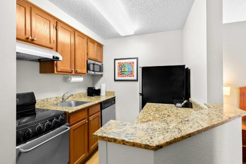 a small kitchen with a stove and a sink at MainStay Suites Middleburg Heights Cleveland Airport in Middleburg Heights