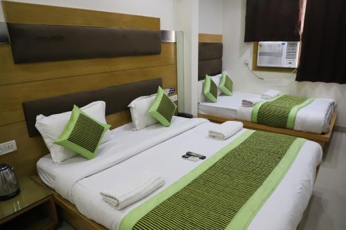 two beds in a hotel room with green and white pillows at Hotel Lav Kush Deluxe 2 Min Walk From New Delhi Railway Station in New Delhi
