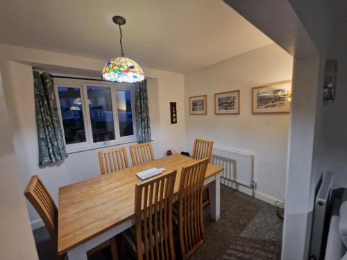 a dining room with a wooden table and chairs at Entire 3 bedroom house 5 minutes from the beach in Kent