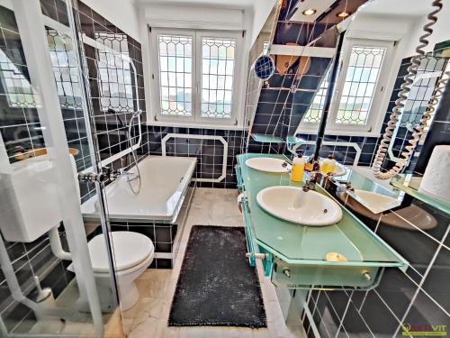 a bathroom with two sinks and a toilet at Das Holland in Kapfenstein