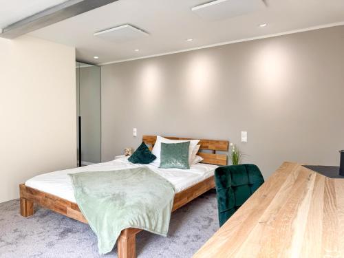 a bedroom with a bed and a wooden table at Kreilingshöfchen Apartments in Bad Vilbel