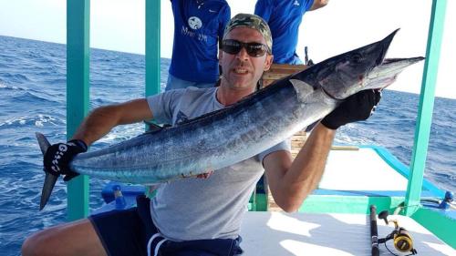 a man on a boat holding a fish at MANTHA VIEW in Felidhoo 