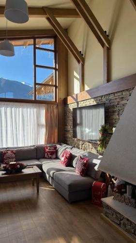a living room with a couch and a television at Villa Pirin Golf in Bansko