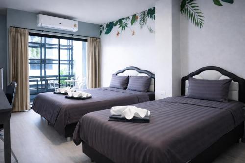 a bedroom with two beds and a balcony at My Friends Hotel in Trang