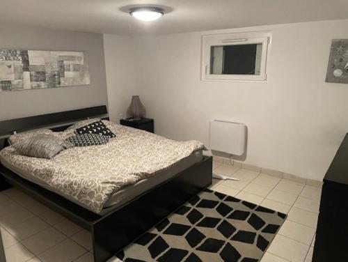 a bedroom with a bed and a black and white rug at Les logis du Landron in Plessé