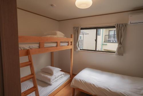 a bedroom with two bunk beds and a window at Tipy records inn HALO in Odawara