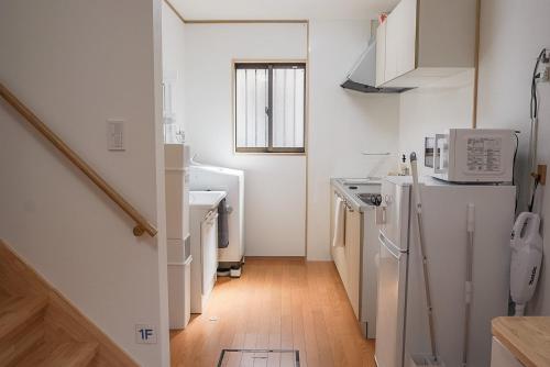 a kitchen with a white refrigerator and a sink at Tipy records inn HALO in Odawara