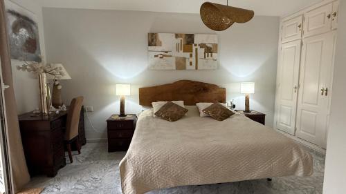 a bedroom with a large bed with two night stands and two lamps at Manilva Beach Casa de Pedro in Manilva