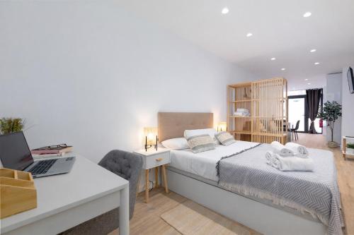 a bedroom with a bed and a desk with a laptop at Valencia Marina Apartment near Beach & City of Arts in Valencia