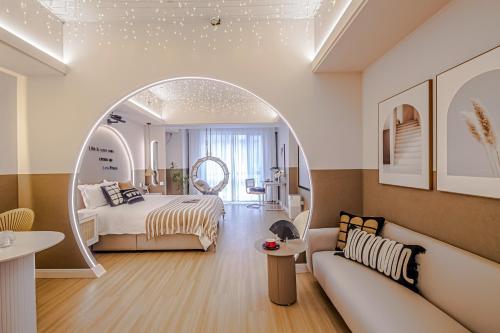 a bedroom with a bed and a living room with a couch at 上海晶彩酒店式公寓江桥万达店 in Shanghai