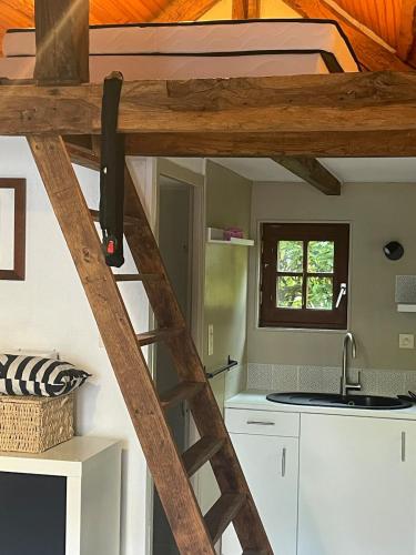 a loft bed in a tiny house at Les logis du Landron in Plessé