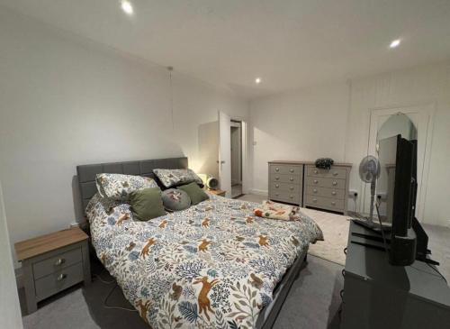 a bedroom with a bed and a flat screen tv at Spacious 3-Bed Terrace, Great Links in Stowmarket