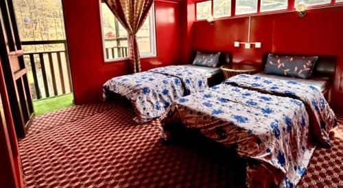 two beds in a room with red walls at LAMA HOTEL - HIMALAYAN BURGER Experience the best stay in EVEREST with an unforgettable Mountain Flight in Lukla