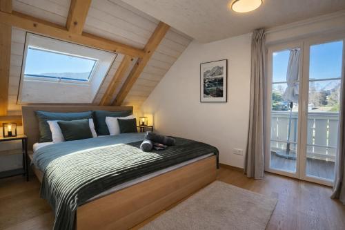 a bedroom with a large bed with a large window at Niesen Loft in Spiez