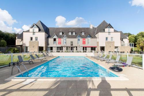 a swimming pool in front of a large house at Les Ormes Domaine et Resort in Epiniac