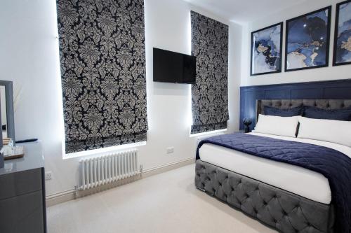 a bedroom with a bed and a flat screen tv at Central Cheltenham Luxury Apartment – Edmonstone House in Cheltenham