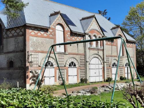 an old church with a swing in front of a church at La Tour de rêves in Beaumont-la-Ronce