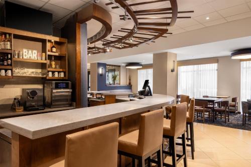 a lobby with a bar with chairs and tables at Hyatt Place Atlanta Airport South in Atlanta