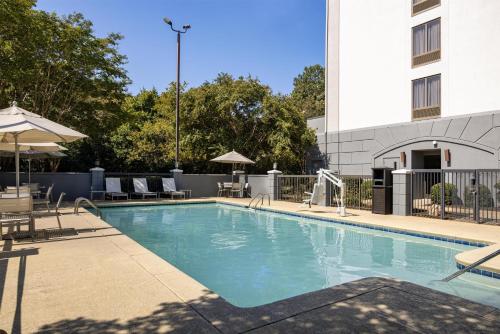 a swimming pool with chairs and a building at Hyatt Place Atlanta Airport South in Atlanta
