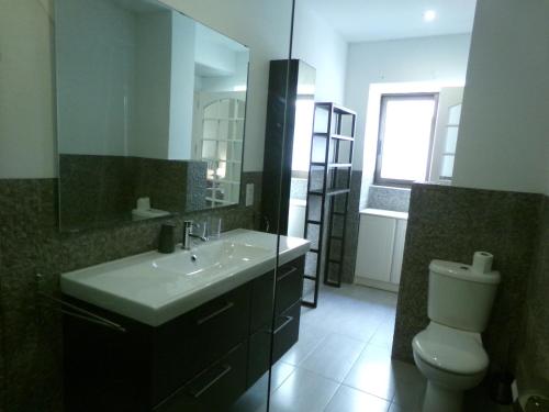 a bathroom with a sink and a toilet and a mirror at Panoramic XL Penthouse Sliema Seafront in Sliema