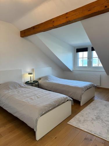 two beds in a room with a attic at Exceptional house by Lake Geneva in Versoix
