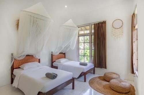 a bedroom with two beds and a window at Villa 3bdrm Sanur 800 m ocean in Sanur