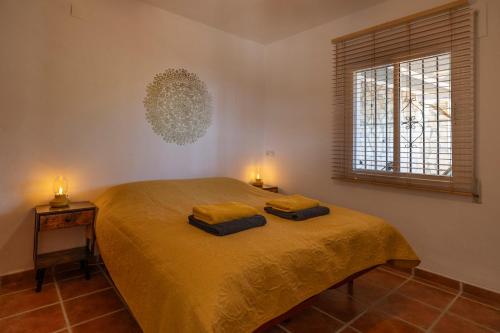 a bedroom with a bed with two towels on it at Casa Mira in Cómpeta
