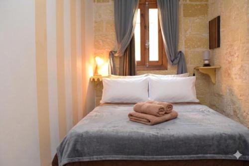 a towel animal laying on top of a bed at St George of Lydda B&B in Victoria