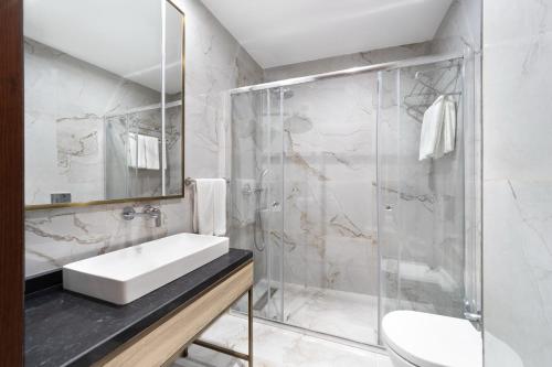 a bathroom with a sink and a shower at Atik Hotel Nişantaşı in Istanbul